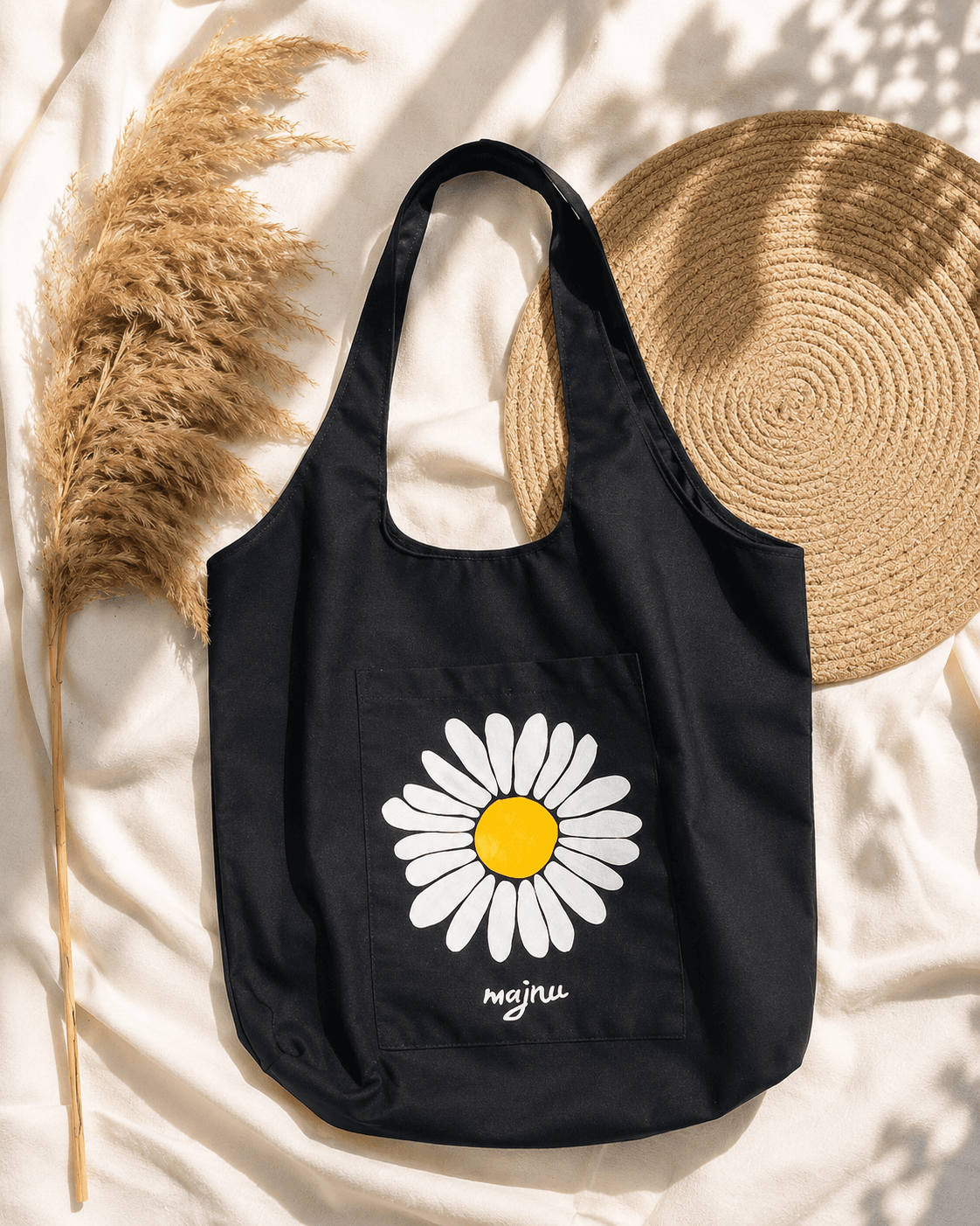 Black canvas tote bag with a hand-painted daisy design and personalised name