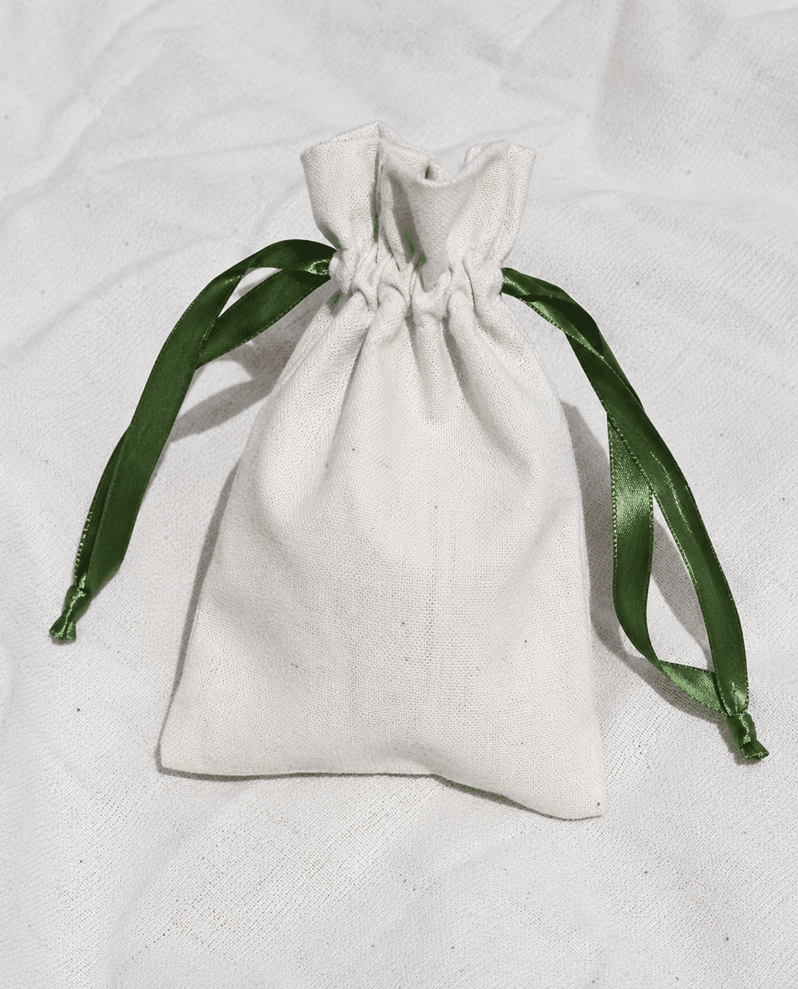 Small drawstring cotton pouch with a green ribbon tie